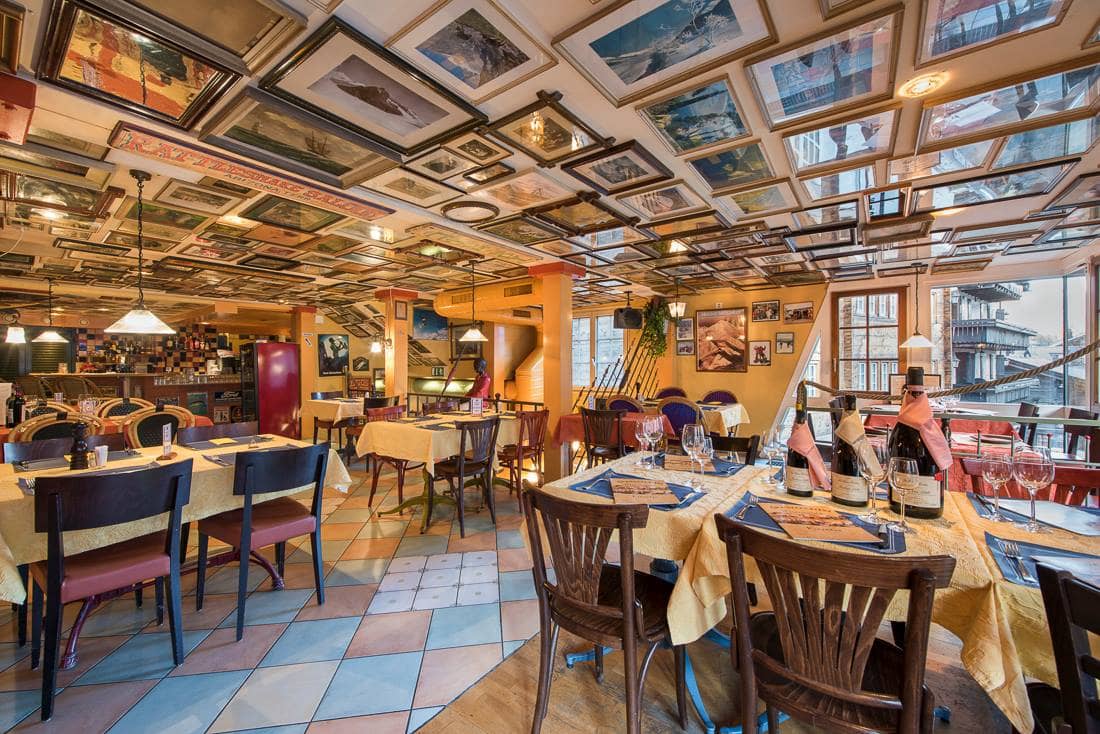 Grampi's Bar and Restaurant interior with tables set for dining and framed pictures covering the ceiling.