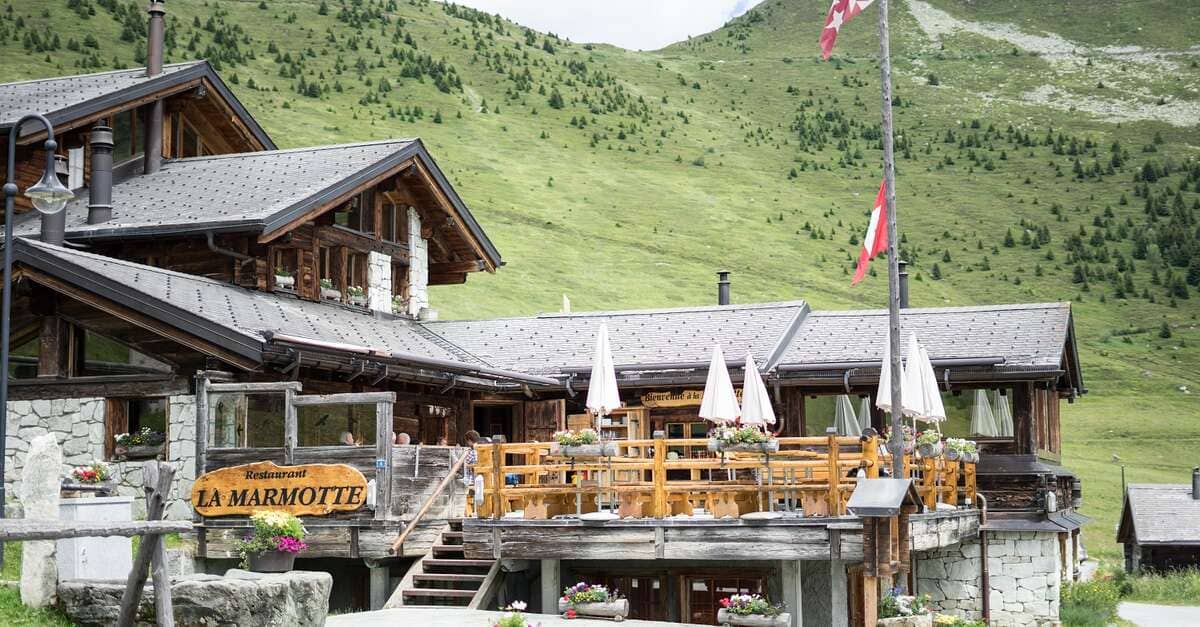Restaurant La Marmotte wooden alpine building with outdoor terrace in mountain setting