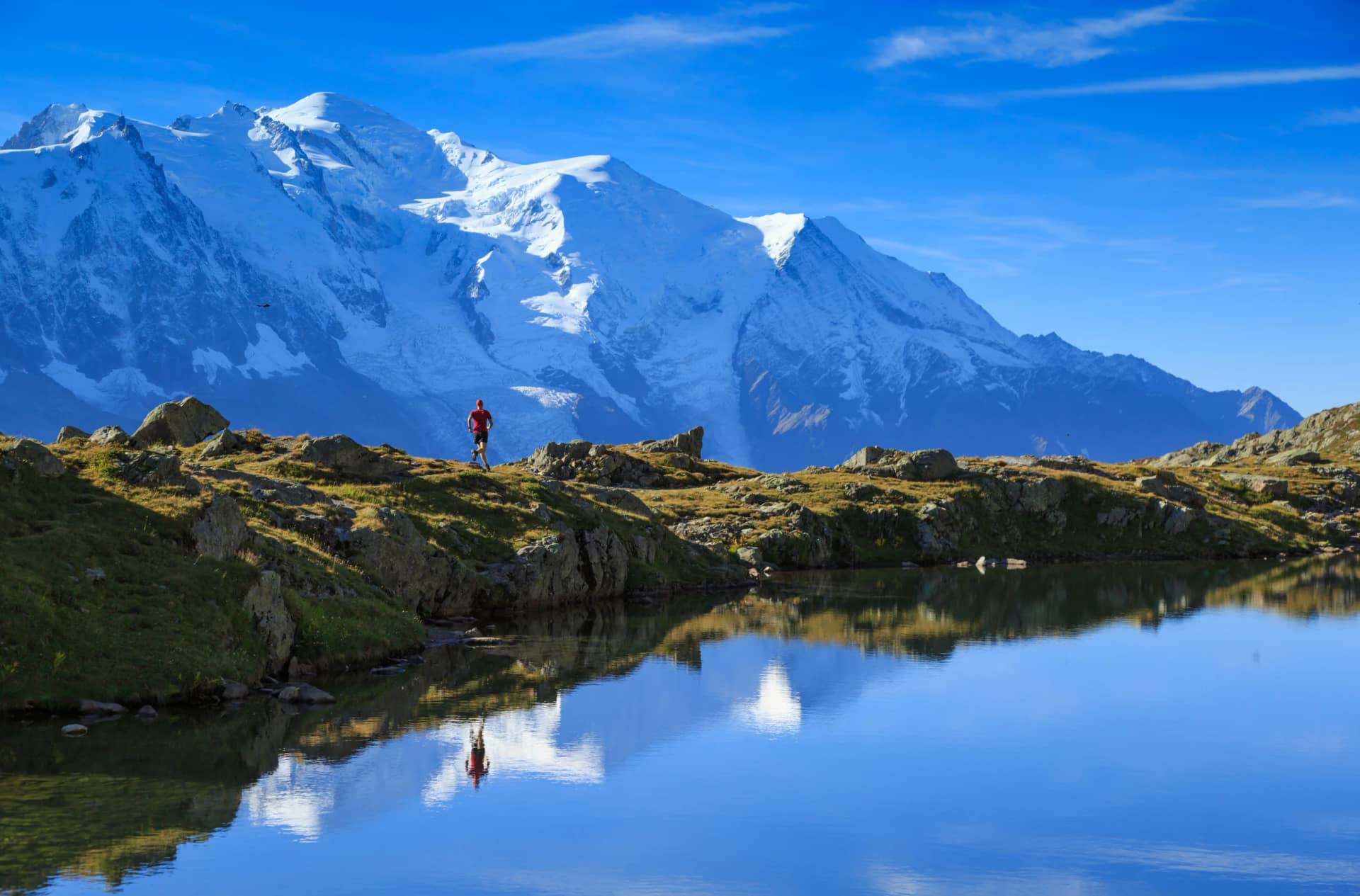 Man trail running at Lac De Chéserys, with the Mont Blanc in the background.