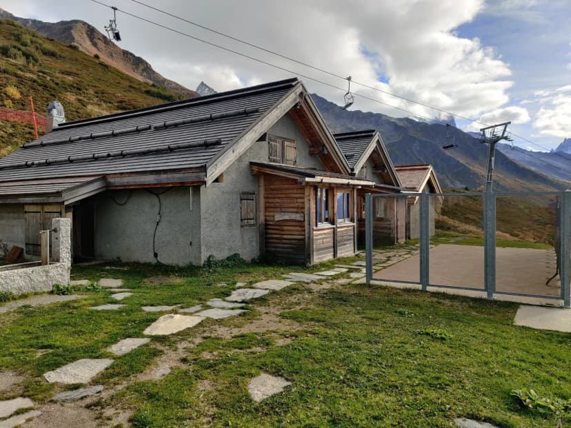 Mountain refuge with ski lift and stone path at Les Écuries de Charamillon