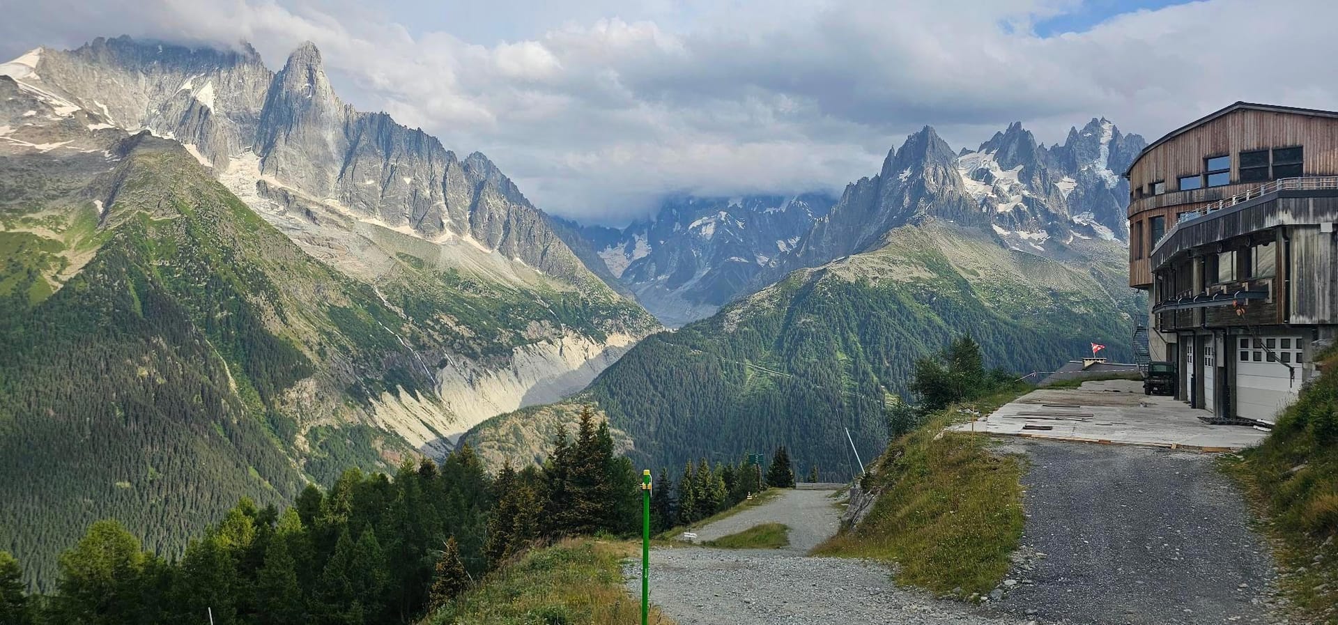 Lac Blanc alpine mountain landscape with rugged peaks, pine forests, and modern building
