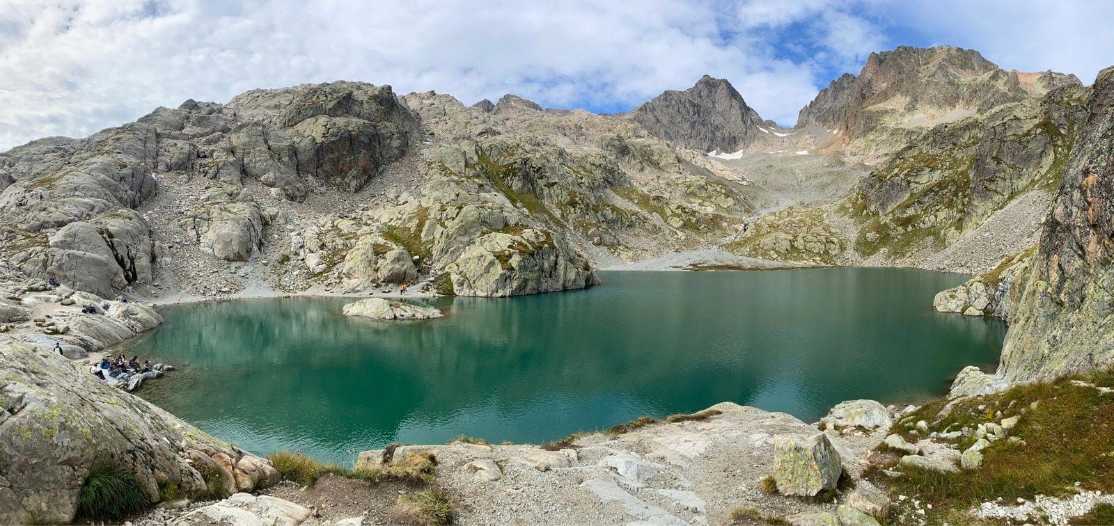 Lac Blanc alpine lake surrounded by rocky mountain peaks and sparse vegetation