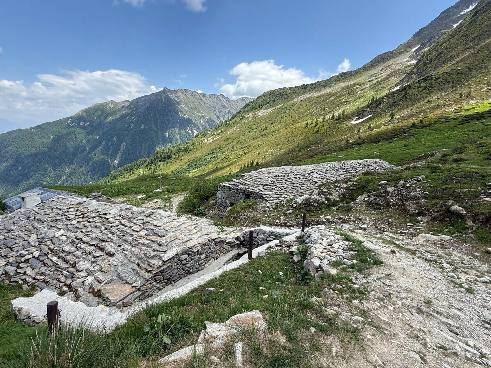 Stone buildings with slate roofs in an alpine mountain valley landscape