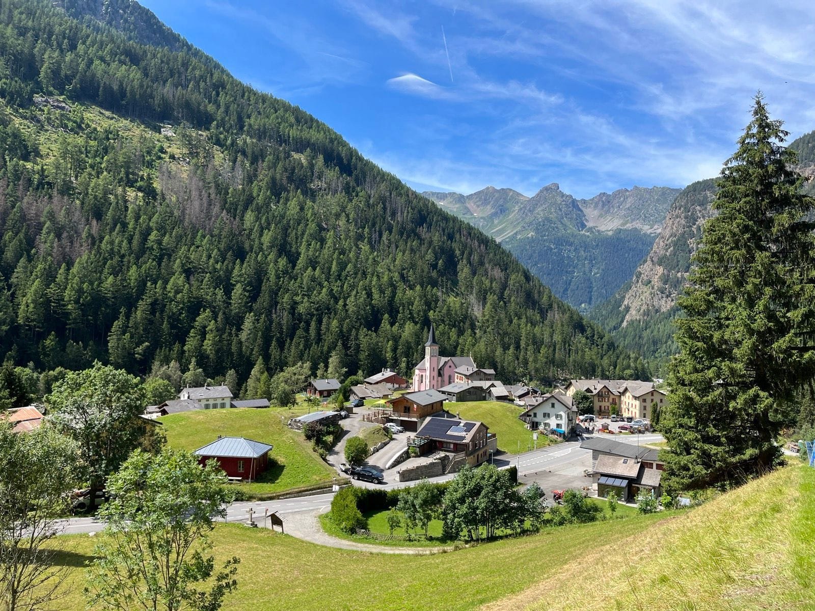 Alpine village of Fen Tête d'Arpette nestled in mountain valley with green slopes and pine forests