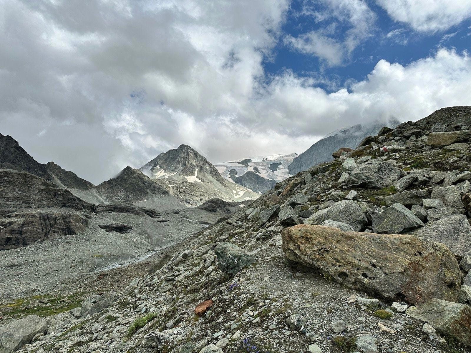 Rocky mountain landscape with glacier peaks under a cloudy sky
