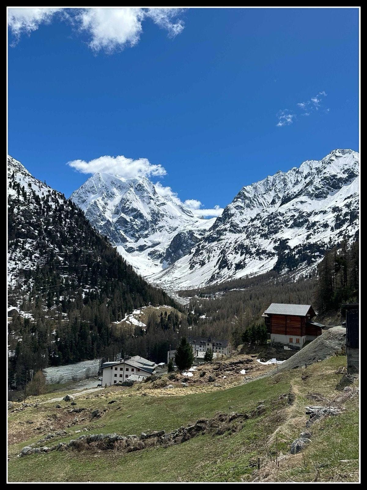 Arolla alpine village with snow-covered mountain peaks and blue sky