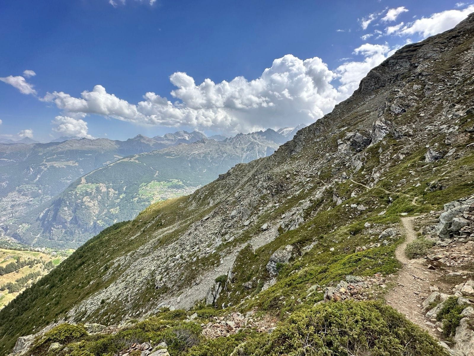 Hiking trail along rocky alpine mountain slope with valley view below