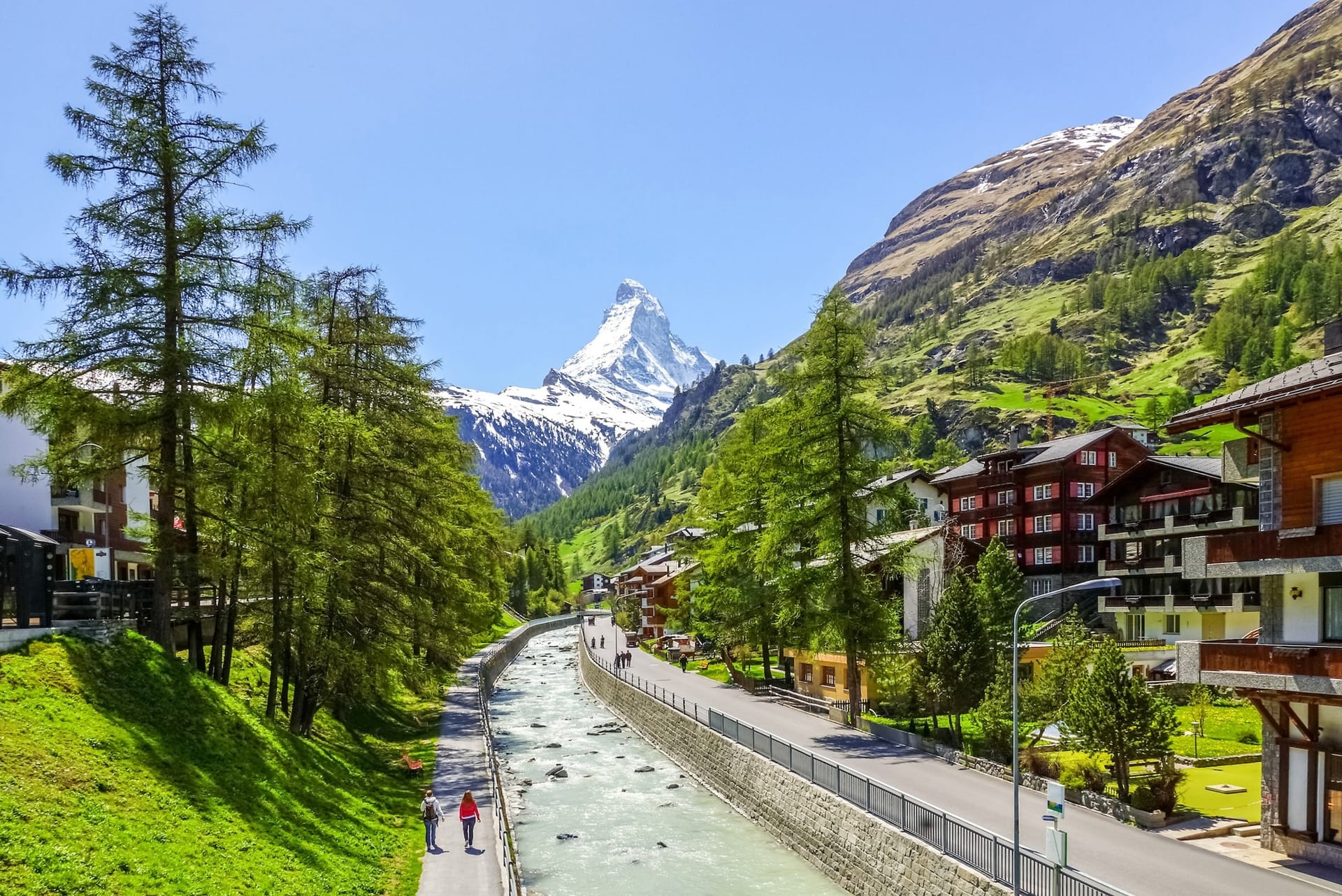 Zermatt alpine village with Matterhorn peak, river, and traditional wooden chalets