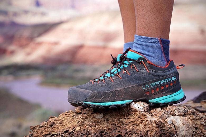 Hiking boots on rocky mountain terrain with canyon background