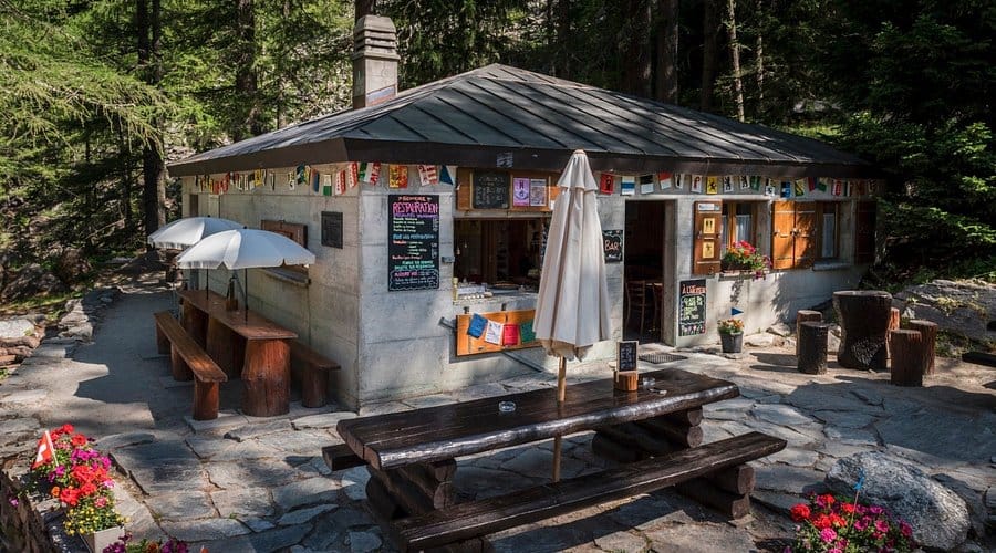 Outdoor cafe and wooden picnic tables in alpine forest setting