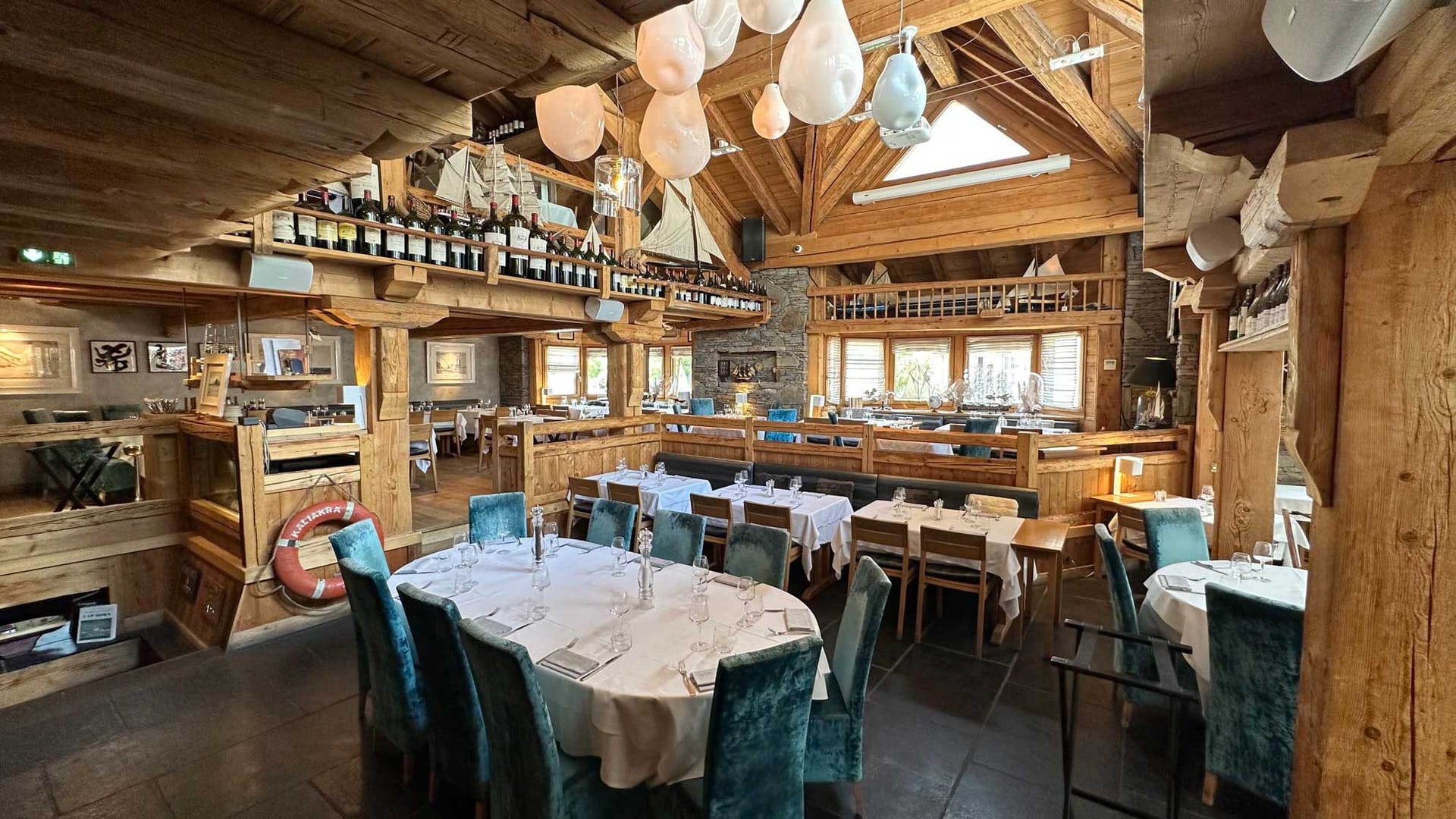 Restaurant interior with wooden timber structure and white tablecloth dining tables