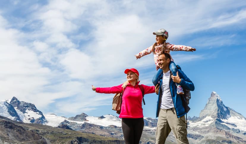 Happy family with little child doing trekking on switzerland mountain in summer time. Young people having fun in landscape nature. Concept of travel, friendly family
