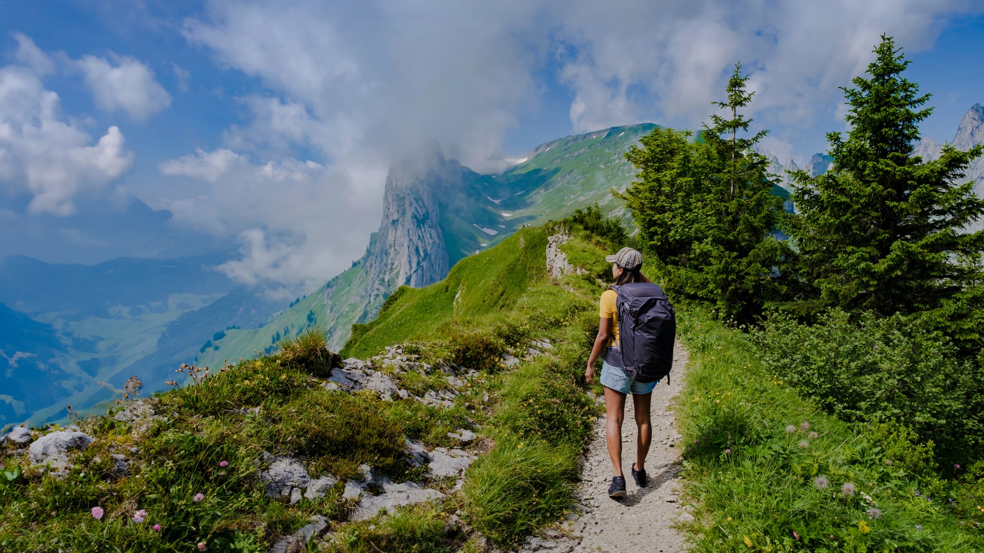women hiking in the Swiss Alps mountains during summer vacation with a backpack and hiking boots. woman walking on the Saxer Lucke path in Switzerland during summer