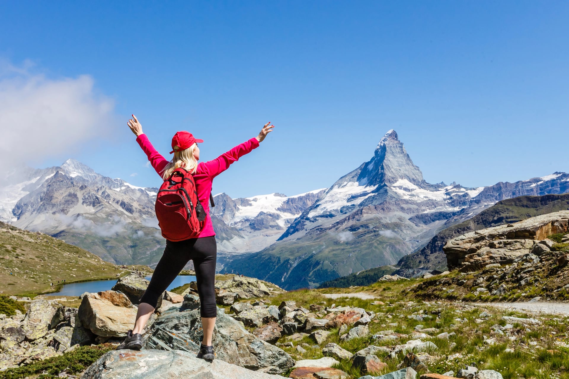 Hiking in the swiss alps with flower field and the Matterhorn peak in the background.