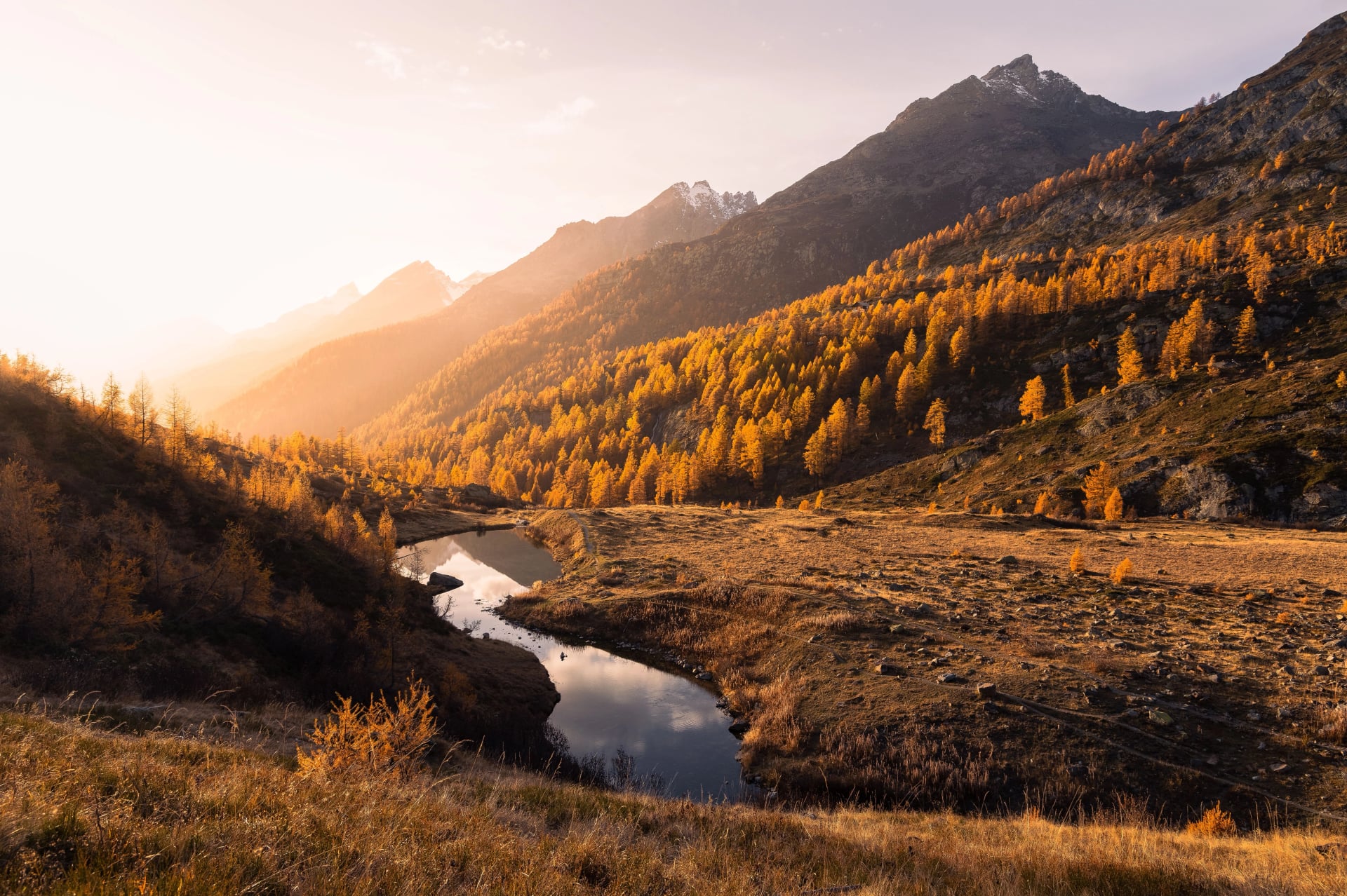 Landschaftsansicht eines Herbstsunsets über dem Grundsee, umgeben von goldenen Lärchen