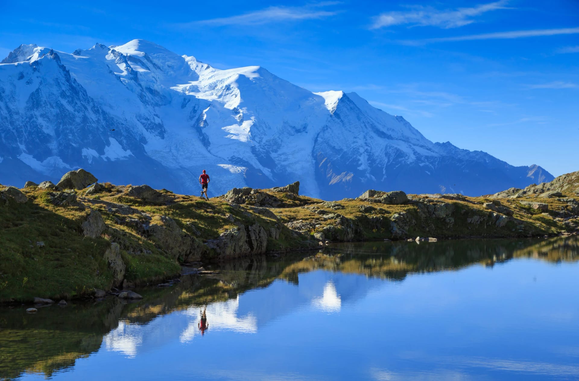 Man trail running at Lac De Chéserys, with the Mont Blanc in the background.
