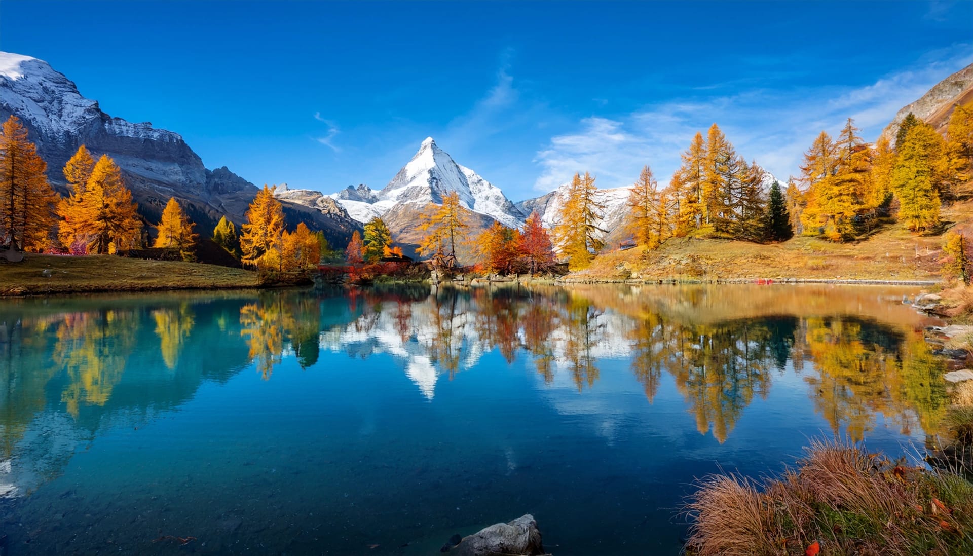 lac bleu of arolla lake in canton valais in colorful autumn season with reflection of dent de veisivi and dent di perroc peaks