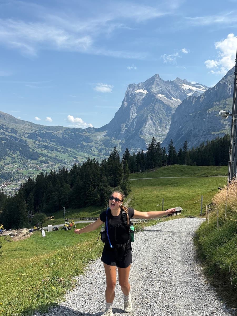 Hiker walking on gravel trail in alpine mountain landscape