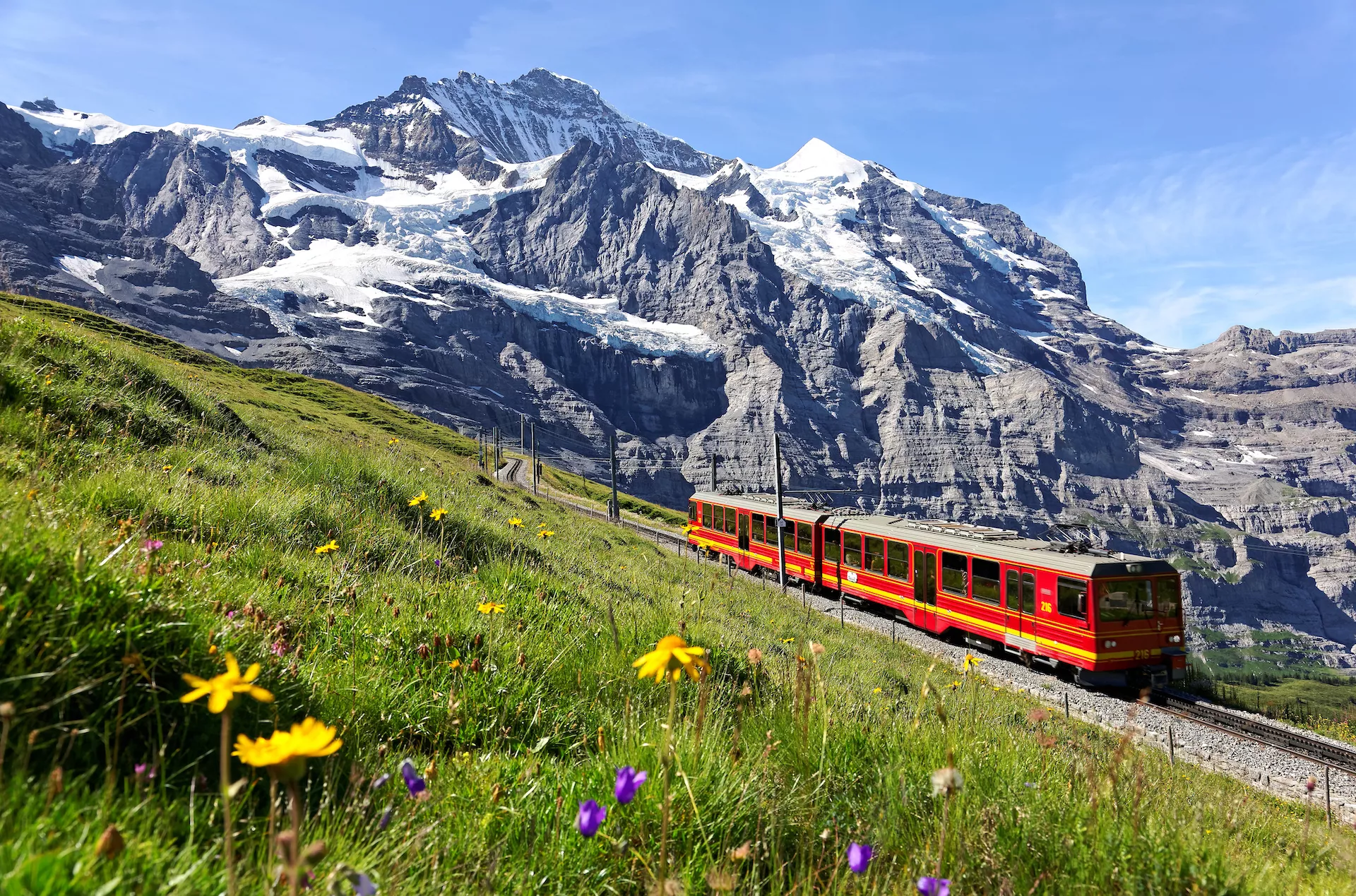 A tourist train travels on Jungfrau Railway from Jungfraujoch to Kleine Scheidegg