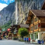 Spectacular principal street of Lauterbrunnen with and stunning Staubbach waterfall in background