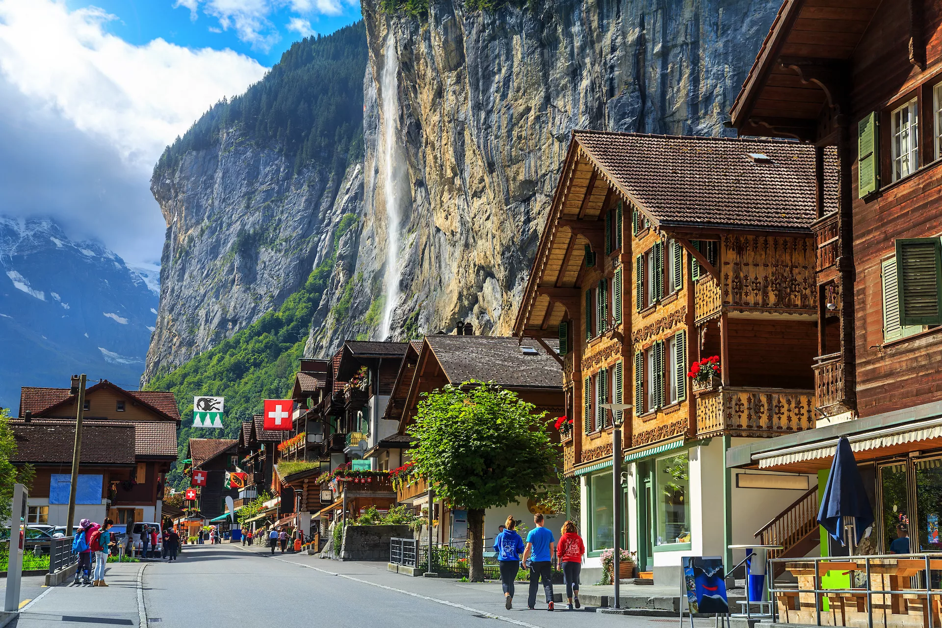 Spectacular principal street of Lauterbrunnen with and stunning Staubbach waterfall in background